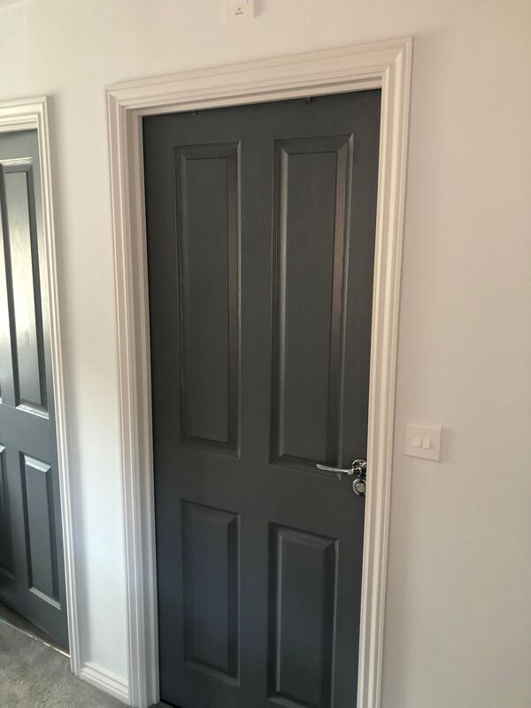 A picture of a door painted dark grey with white frame by Painters and Decorators Rotherham